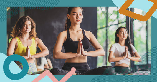 Women in activewear meditating in a yoga class